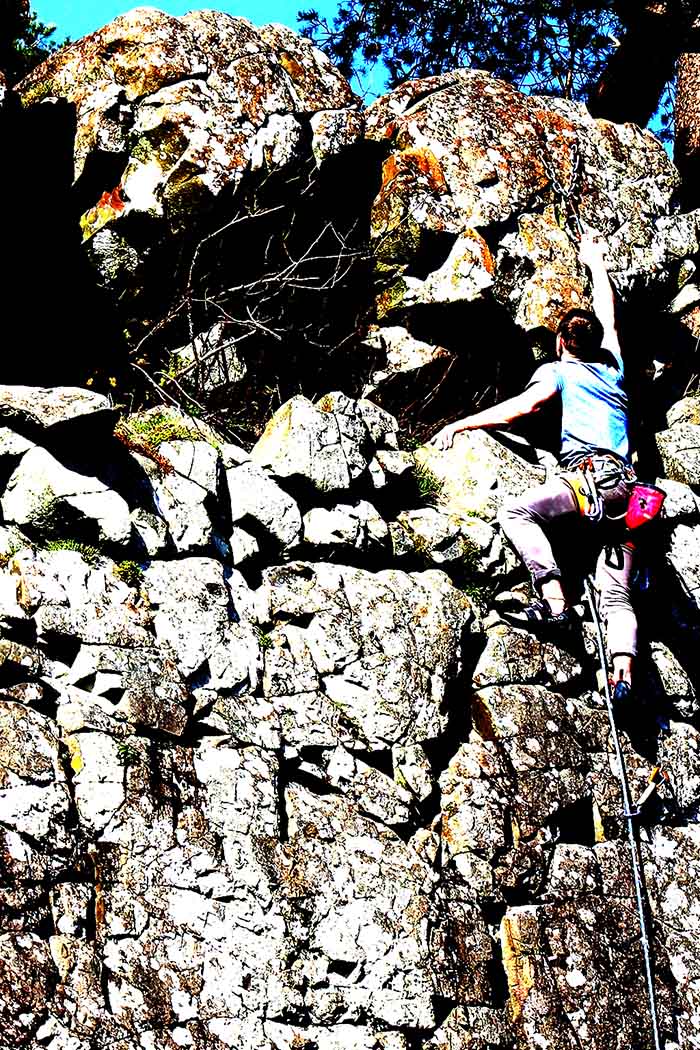man climbing a rockface